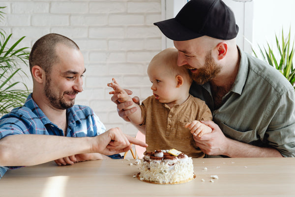 Young couple with a feeding a baby cake