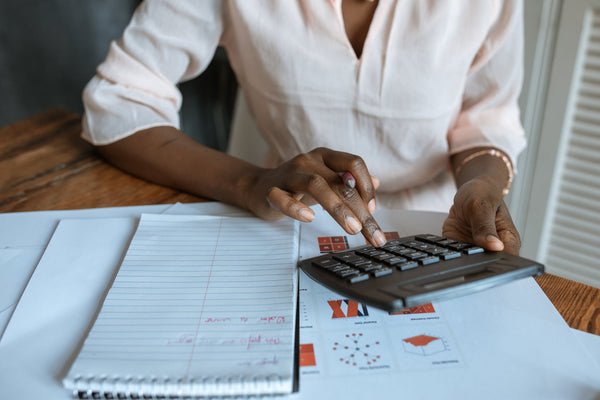 A women using a calculator whilst looking at the financial plan